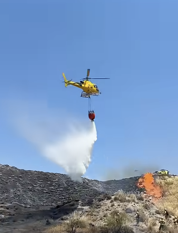 Helicopter dropping water over wild fire